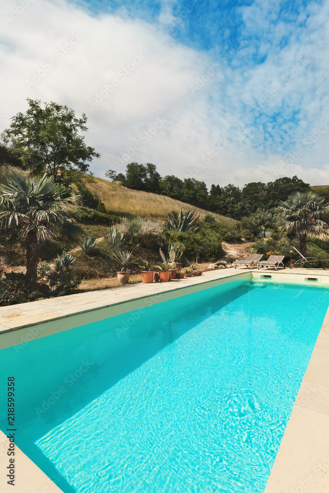 Beautiful swimming pool with mediterranean garden, view from poolside