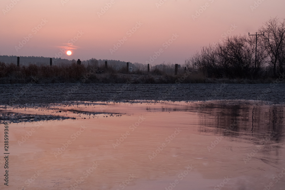 amazing of sunrise in February. Forest and lake.. Cold weather