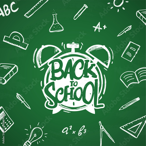 Hand drawn typographic lettering of Back to School with alarm clock and doodles supplies on blackboard background