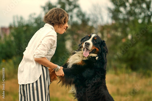 Fotografie a girl and a large dog dog stands on its hind legs.