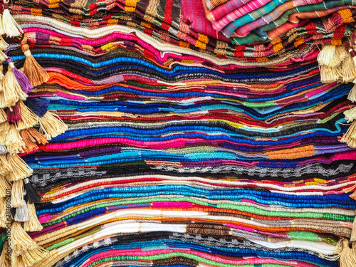 Colorful arabic rugs piled up at the market in Morocco