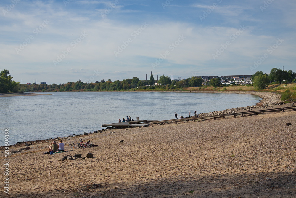 Scenery of beach and riverside on sunny day. People enjoy natural landscape at the beach around riverside of Rhine river in Düsseldorf, Germany during sun shine day. Scenery of beach and riverside on sunny day. People enjoy natural landscape at the beach around riverside of Rhine river in Düsseldorf, Germany during sun shine day.