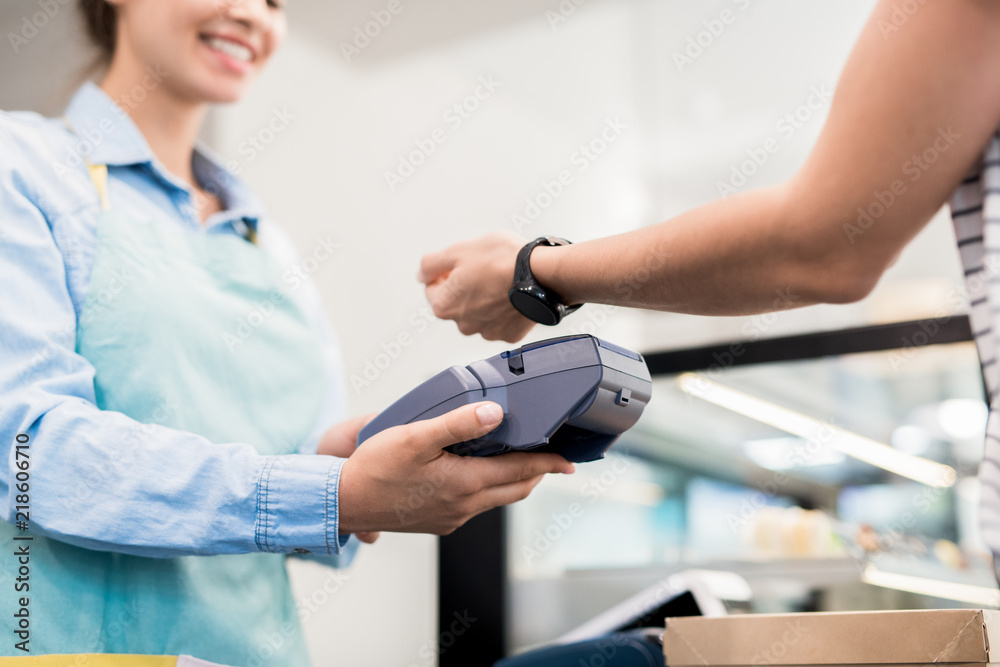 Low angle close up of unrecognizable woman paying via smart watch in local  bakery, copy space Stock Photo | Adobe Stock