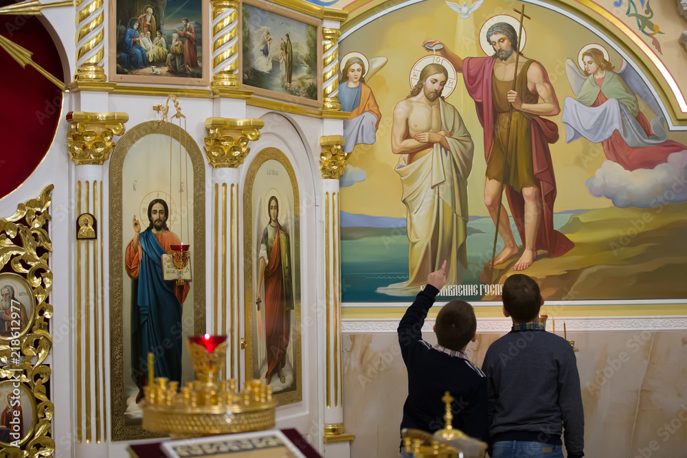 Belarus, the city of Gomel, June 15, 2018. Central church.Molitical day.The children in the church are looking at icons Belarus, the city of Gomel, June 15, 2018. Central church.Molitical day.The children in the church are looking at icons
