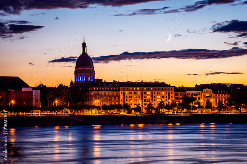 Moonrise and sunset lights over the Christuskirche in Mainz, in the foreground the river rhine, Germany photo