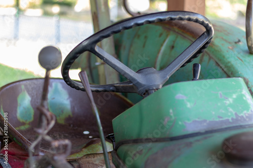 Cabin with steering wheel of an old green tractor