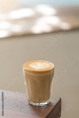 A Cup of Piccolo latte coffee with latte art on the wooden table background.