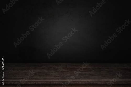 old wood table in front of dark and gray abstract cement wall and studio room gradient background