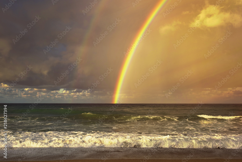 Rainbow over the sea and tropical beach.