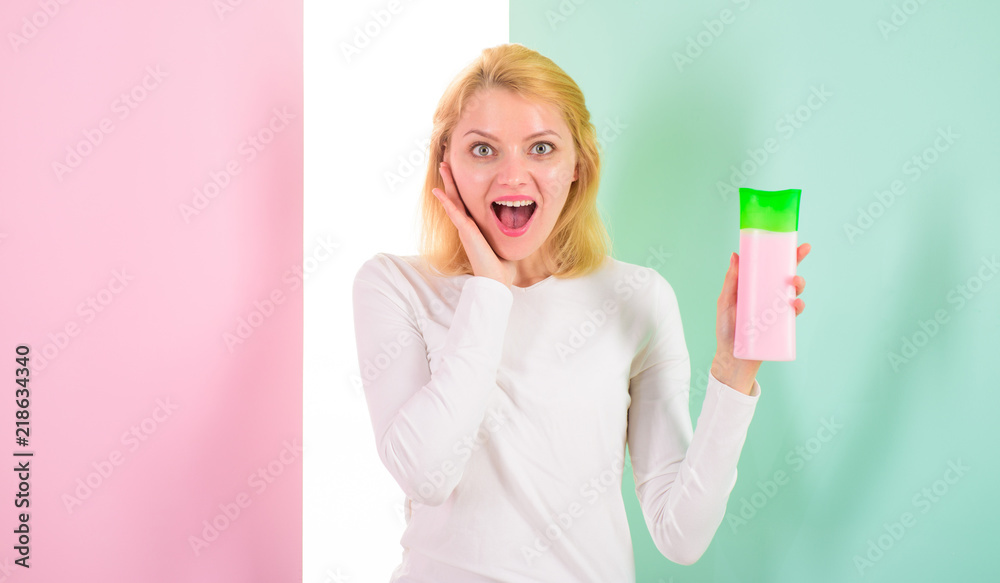 Shocking tips achieve incredible hair. Protect hair before heat styling. Apply protective product first. Hair styling tips. Woman shows beauty product for hair. Girl blonde holds shampoo bottle