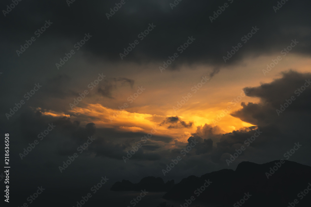 dark dramatic sky during golden yellow sunset on exotic island, thailand