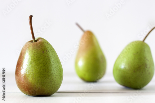 Fresh ripe pears lie on a white wooden table