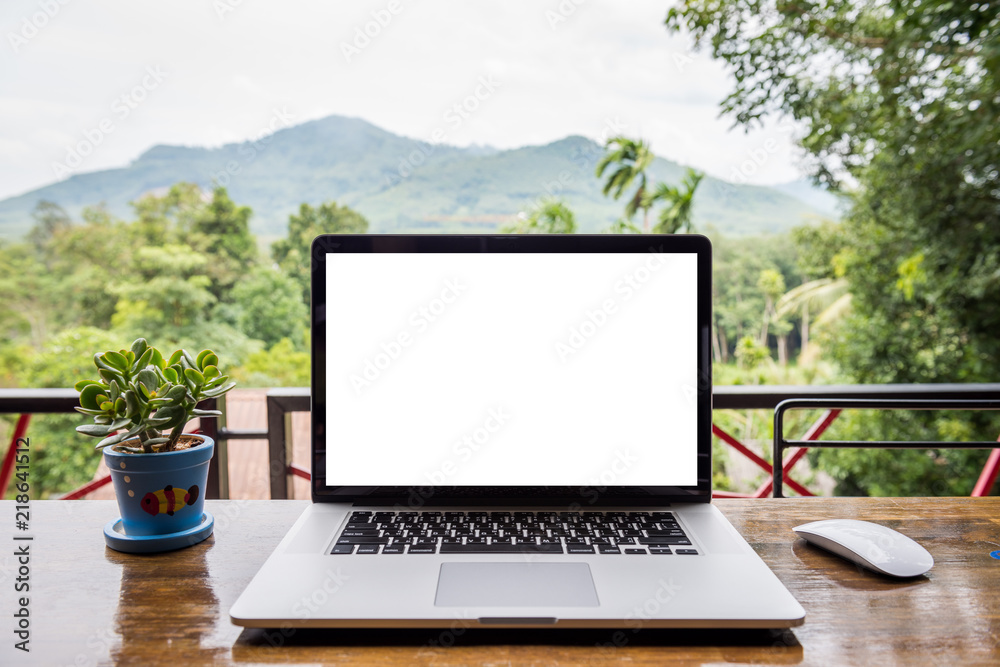 blank screen of laptop with mouse and plant vase on wooden table, Mountain and forest background blank screen of laptop with mouse and plant vase on wooden table, Mountain and forest background