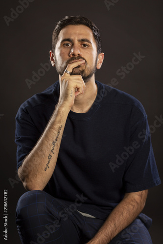 Cute man sits lost in thought
