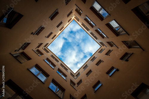 Bottom view of square sky from patio of urban house in Helsinki, Finland, abstract geometric urban background with blue sky and clouds