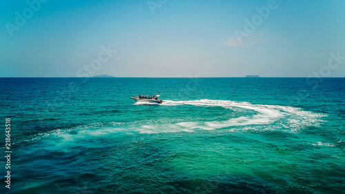 Ferry at the Gulf of Siam. Aerial view of floating ferry at sunset. Colorful landscape with boat, turquoise sea. Top view from drone of yacht. Seascape with motorboat © yuliya