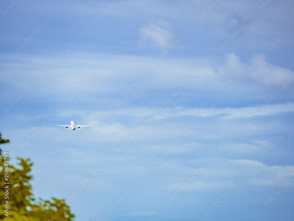 Fototapeta premium travel and transportation concept from back of aircraft fast fly after take off from runway with blue sky and cloud background