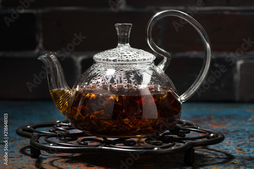tea masala in a glass teapot on a dark background, closeup