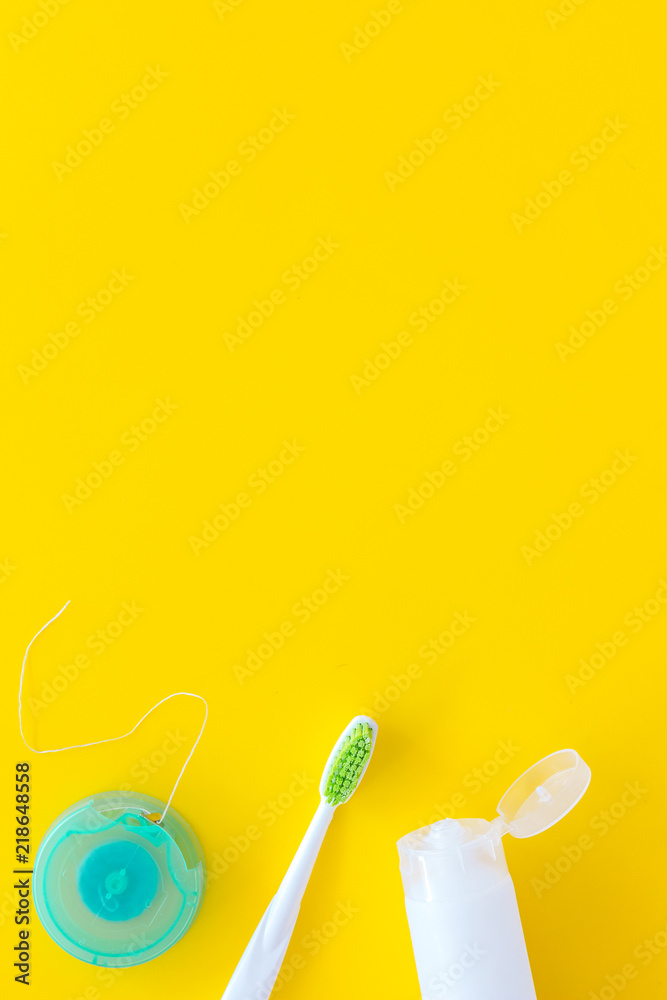 Set for daily teeth care. Toothbrush, tooth paste, dental floss on yellow background top view copy space Set for daily teeth care. Toothbrush, tooth paste, dental floss on yellow background top view copy space
