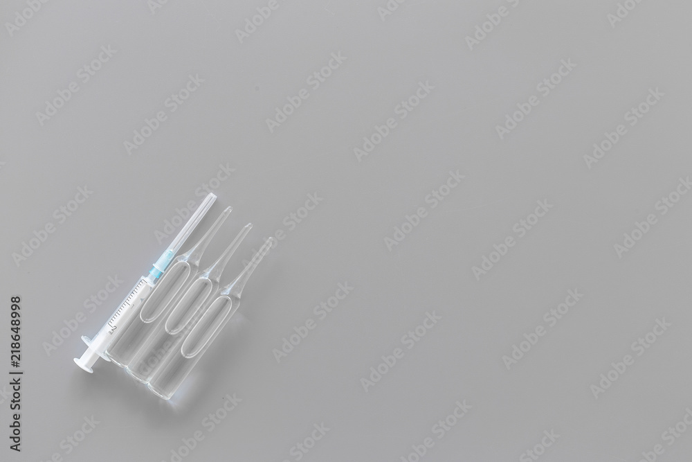 Flu vaccination concept. Syringe and ampoulie on grey background top view space for text Flu vaccination concept. Syringe and ampoulie on grey background top view space for text