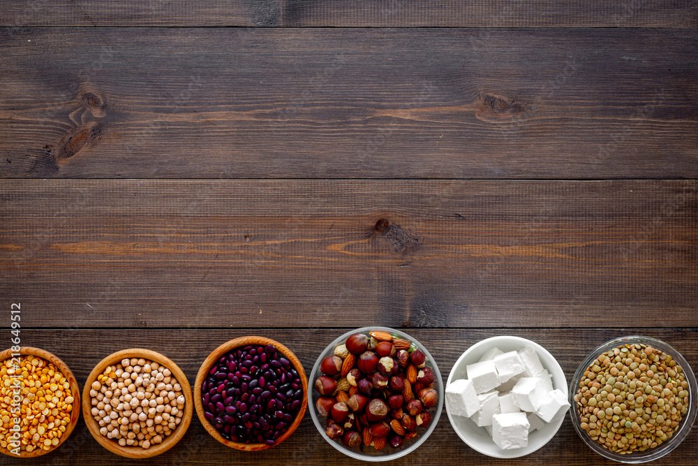 Vegan protein source. Legumes, nuts, cheese. Raw beans, chickpeas, lentil, almond, hazelnut on dark wooden background top view copy space Vegan protein source. Legumes, nuts, cheese. Raw beans, chickpeas, lentil, almond, hazelnut on dark wooden background top view copy space