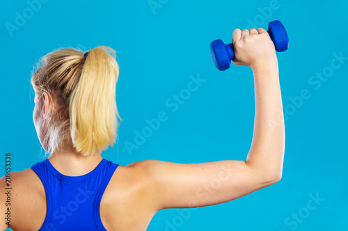 Fit woman lifting dumbbells weights