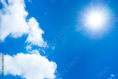 Sonne scheint vom sommerlichen, blauen Himmel, weiße Wolken, Sommer photo