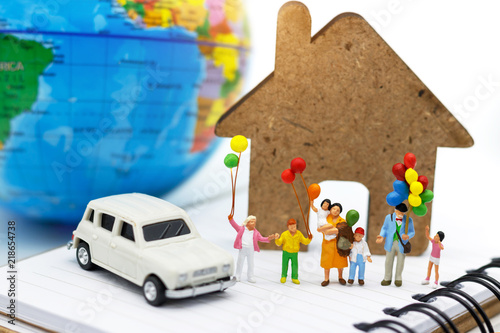 Miniature people, family and children enjoy with colorful balloons, car, house and globe on the book, happy family day concept. photo