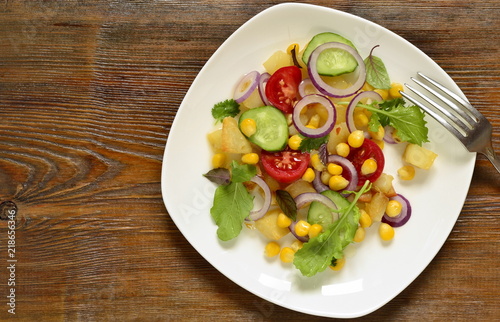 Salad with corn, fresh vegetables and baked potatoes, top view, copy space