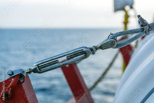 Turnbuckle securing liferaft on a construction barge