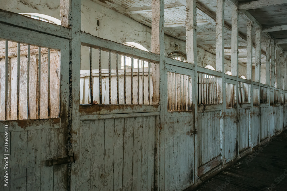 Fototapeta premium Inside old wooden stable or barn with horse boxes, corridor