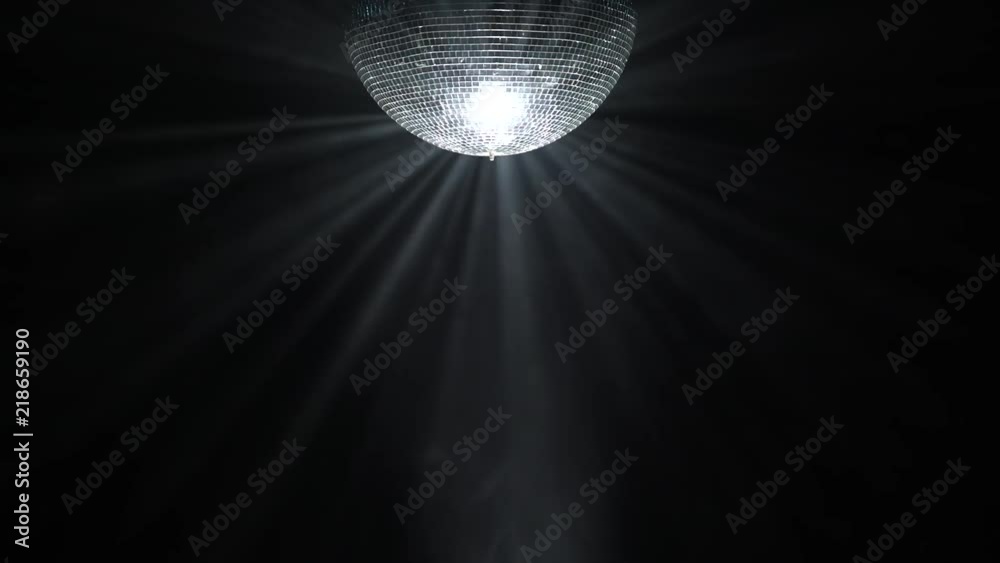 Silver mirror disco ball rotating in black space