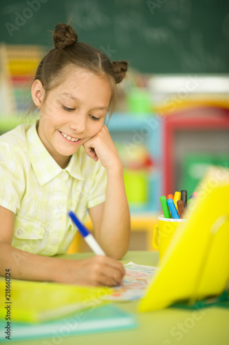 Portrait of a cute girl doing homework