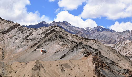 Helicopter flies over Ladakh mountain ranges with tourists on sightseeing tour