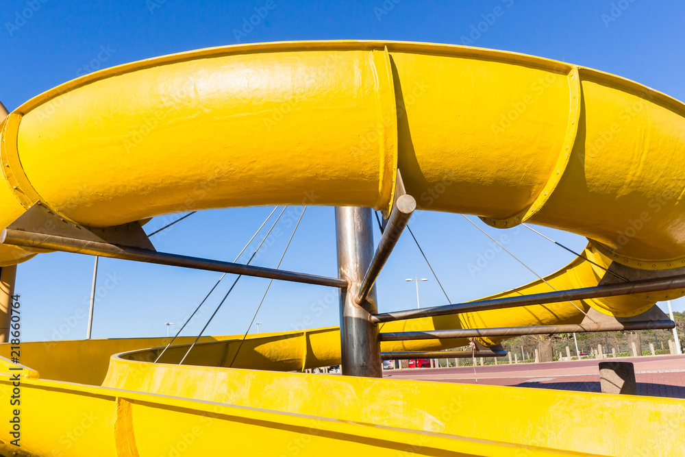 Naklejka premium Amusement Yellow Water Slide Park Closeup