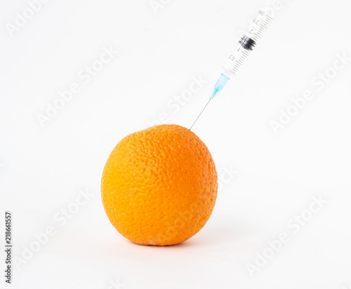 Orange on a white background in which enter gmo and nitrates, close-up, genetically modified organism, orange
