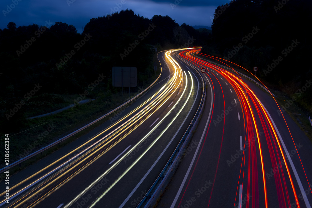 Car lights on a mountain road at dusk
