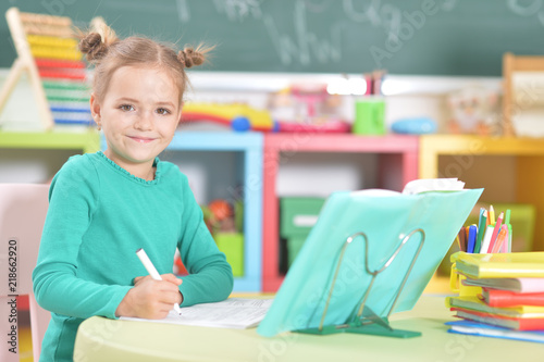 Portrait of a cute schoolgirl doing homework