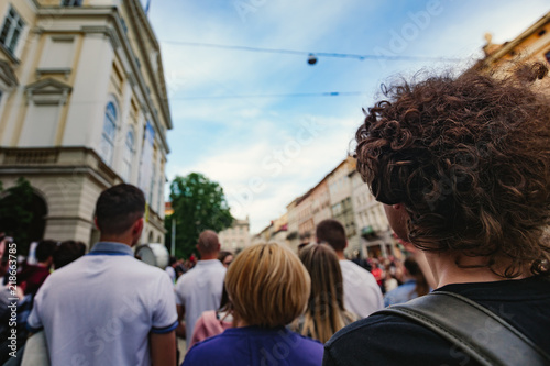 Back view of audience watching street performance