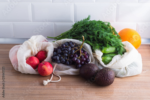 Fresh grocery produce in reusable cotton bags, zero waste concept photo