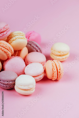 Sweet macaroons with vintage pastel colored tone on pink background.