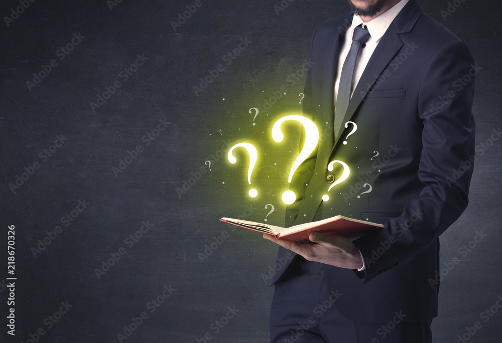 Businessman holding a book with question mark symbol. Businessman holding a book with question mark symbol.