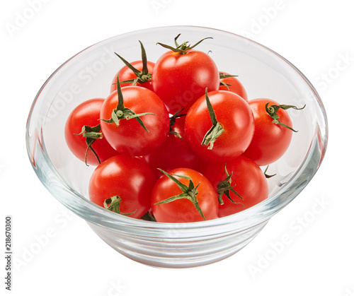 Fresh ripe tomatoes in glass bowl isolated on white background with green leaf. Ingredients for cooking. Top view.