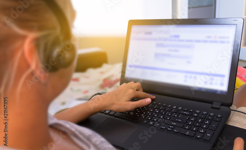 girl operator in headphones working at computer at home