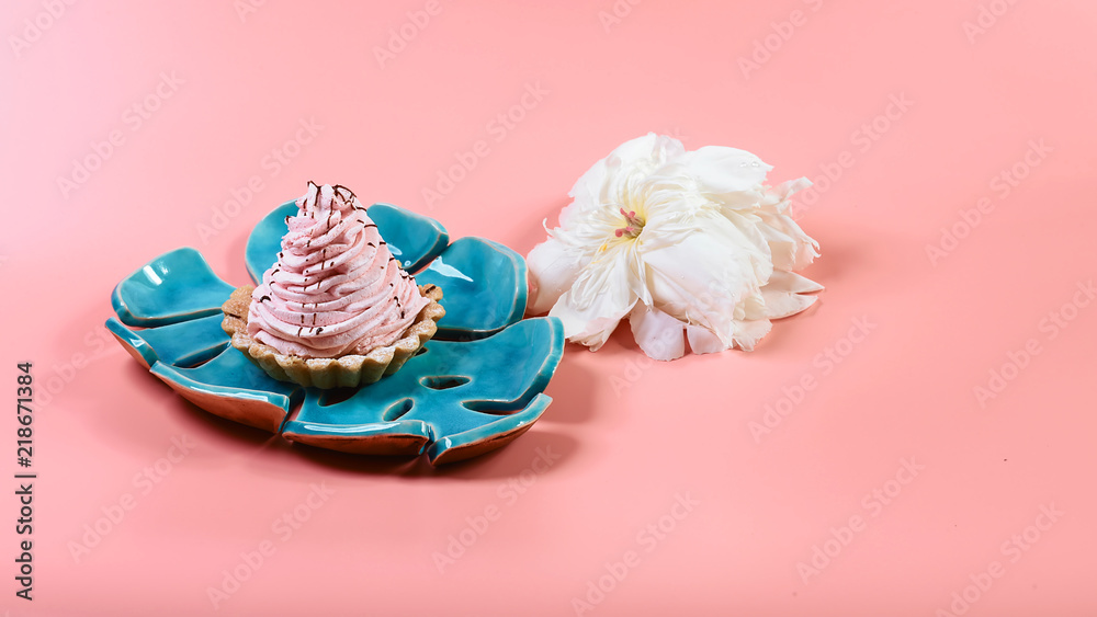 delicious dessert on a blue decorative plate, pink and white flowers pions on a pink background, copy space, Flat lay