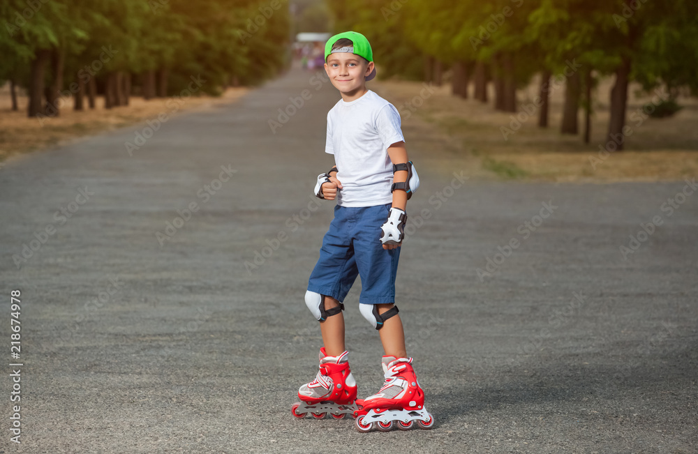 The boy skates in the park in the summer. The boy skates in the park in the summer.
