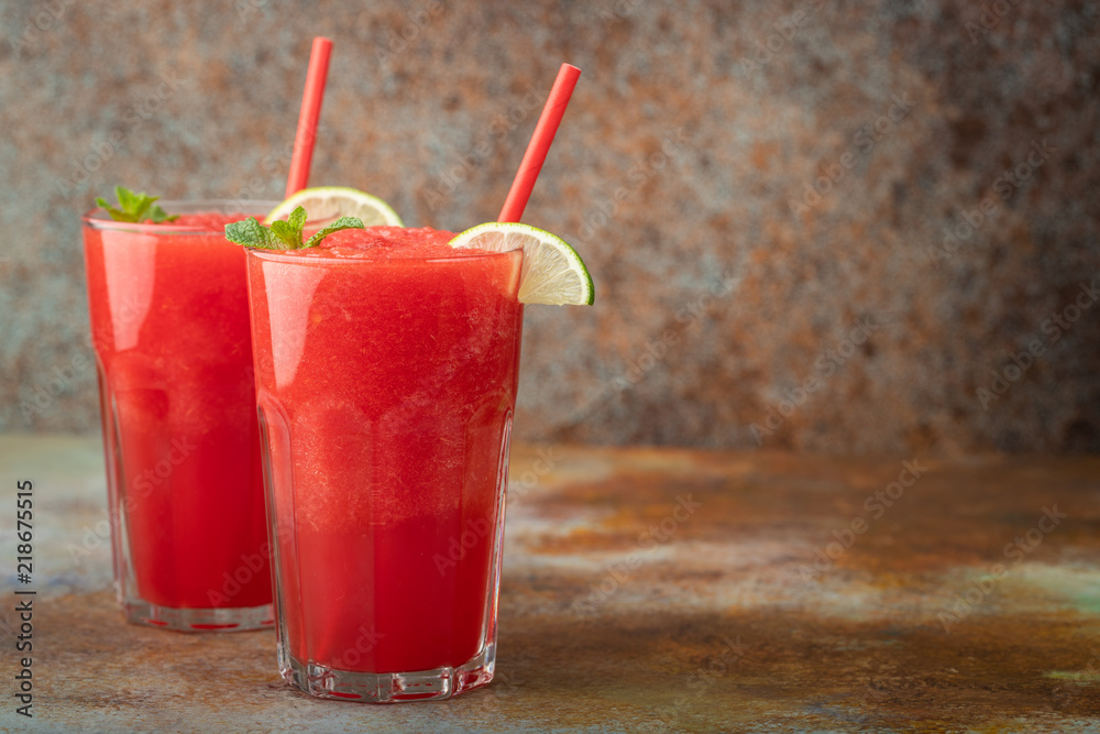 Watermelon slushie with lime, summer refreshing drink in tall glasses on a blue rusty background. with copy space Watermelon slushie with lime, summer refreshing drink in tall glasses on a blue rusty background. with copy space