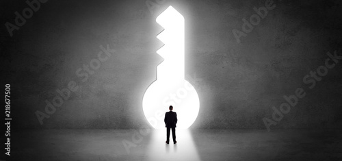 Businessman standing alone in front of a big keyhole
 photo