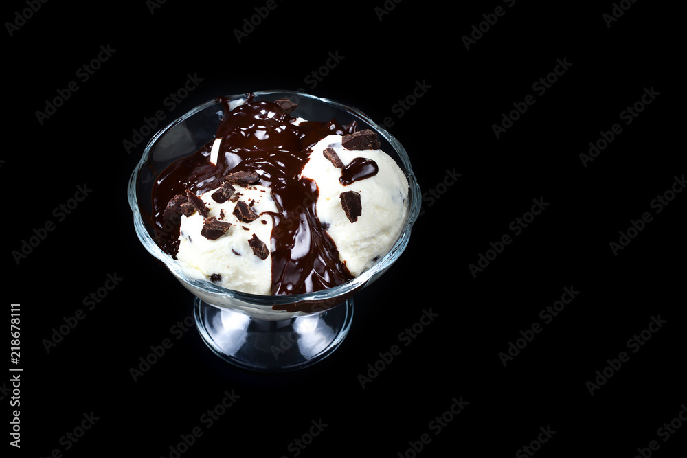 Vanilla ice cream in a white bowl with chocolate on a black background. Vanilla ice cream in a white bowl with chocolate on a black background.