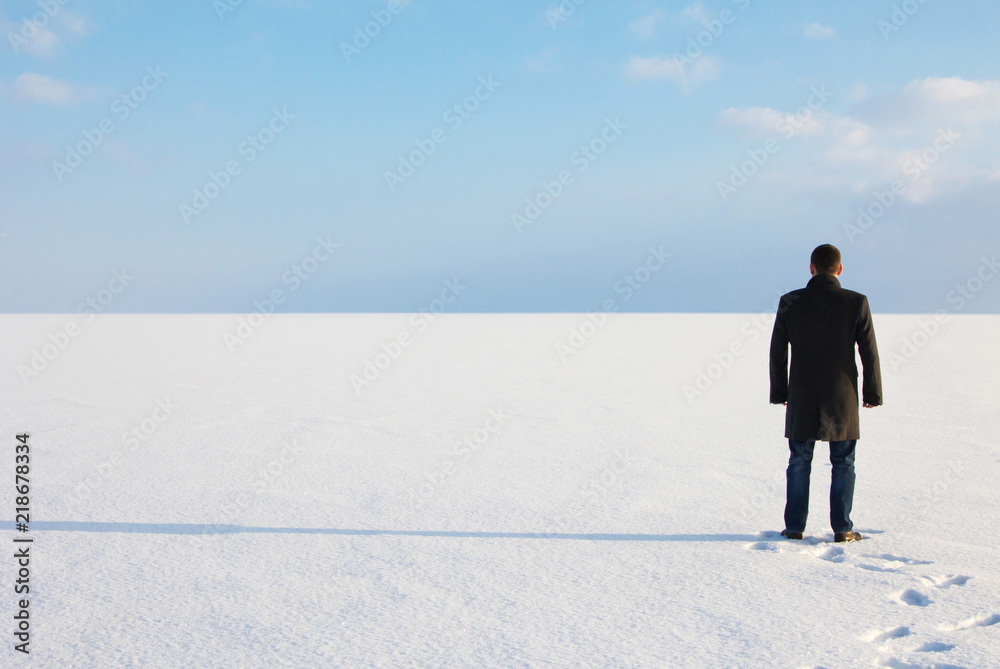 man standing on the shore of a frozen sea downshifting way relaxes on a winter seascape man standing on the shore of a frozen sea downshifting way relaxes on a winter seascape